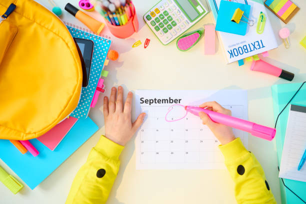 vista superior del niño moderno con libros de trabajo en la mesa blanca en casa - calendar september education month fotografías e imágenes de stock