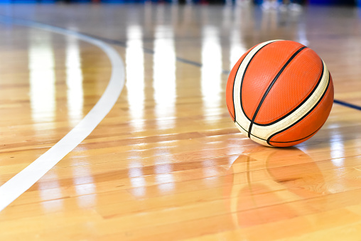 Basketball ball on Court Floor close up with blurred background.
