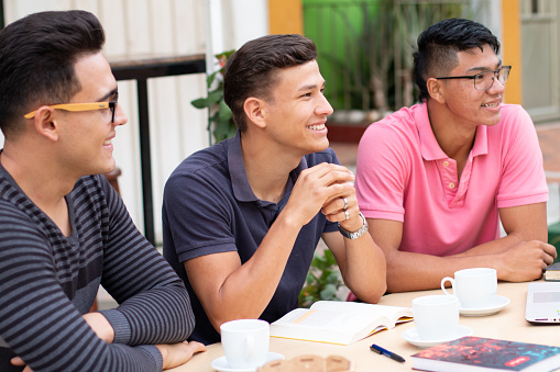 three latin students looking at the same place and smiling