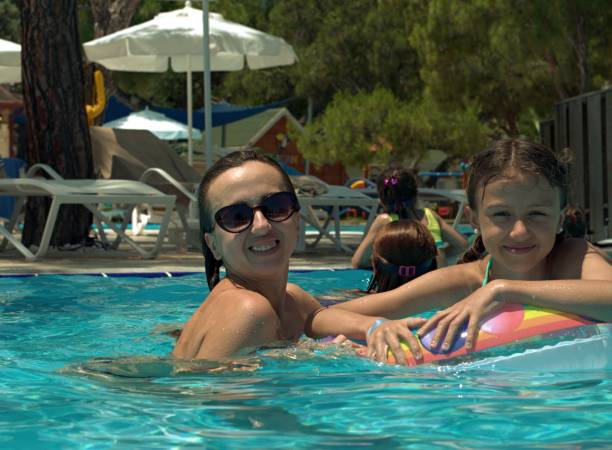 istock Daughter and mom having fun in the pool 1337550562
