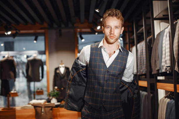 istock Handsome man with beard choosing jacket in a shop 1337556585