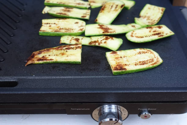 istock Zucchini cut into strips brushed with olive oil during cooking on a baking sheet 1337561188