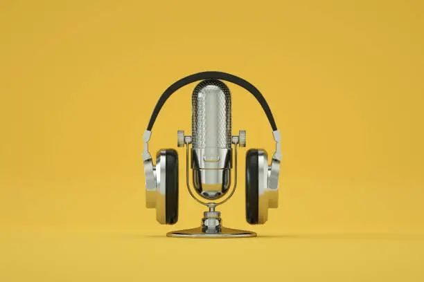 Photo of Retro Old Microphone and Headphones, Vintage Style, Yellow Color Background