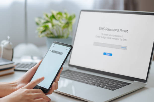 istock Woman hand holding phone showing security code and enters one-time password for the validation process on laptop, Mobile OTP secure Verification Method, 2-Step authentication web page. 1337565050