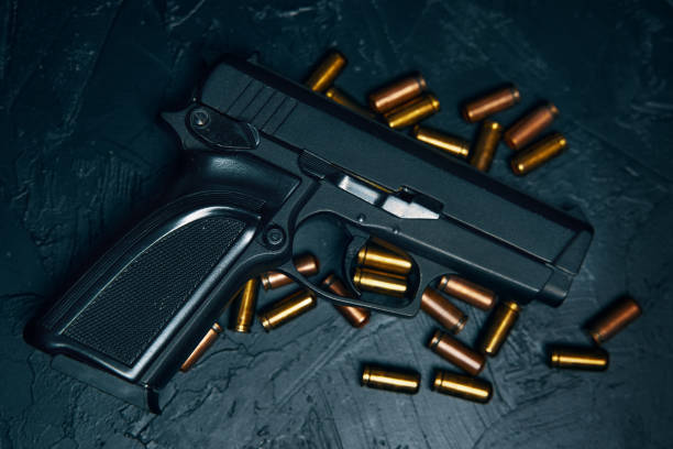 istock Gun with cartridges on dark concrete table. 1337567821
