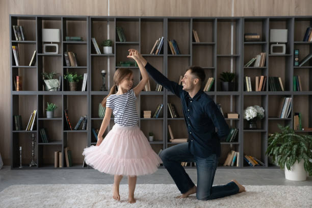 istock Daughter in fluffy skirt swirling enjoy dance with daddy 1337568643