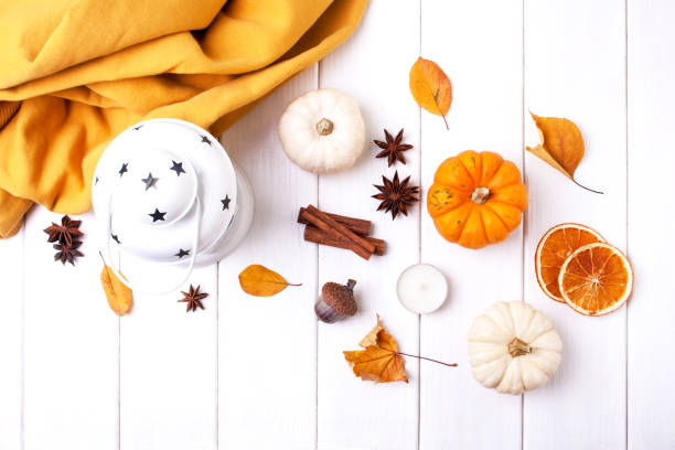 istock Autumn leaves, pumpkins and a white lantern on a white background. View from above 1337571055