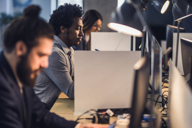 istock African American computer programmer working next to his colleagues at corporate office. 1337571943