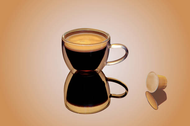 istock Double walled glass cup of coffee, coffee pod on reflecting surface 1337572962