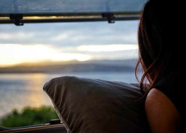 istock Woman looking sunrise through the window 1337573039