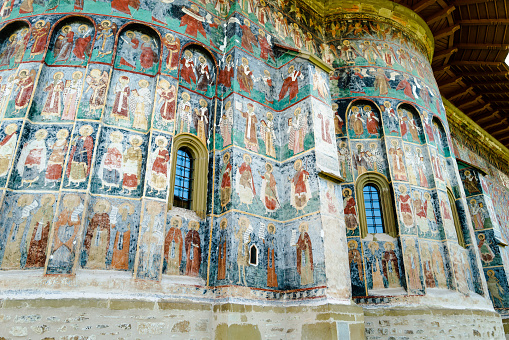 Moldovita, Romania - 5 August, 2021: Color image depicting the ancient architecture and murals of Moldovita monastery in the north of Romania.