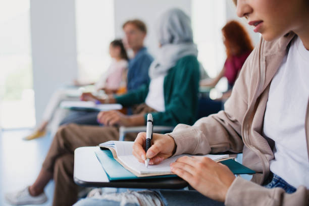 istock Group of unrecognizable university students sitting in classroom indoors, studying. 1337578005