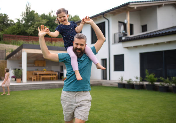 istock Father with daughters playing outdoors in the backyard, running. 1337578772