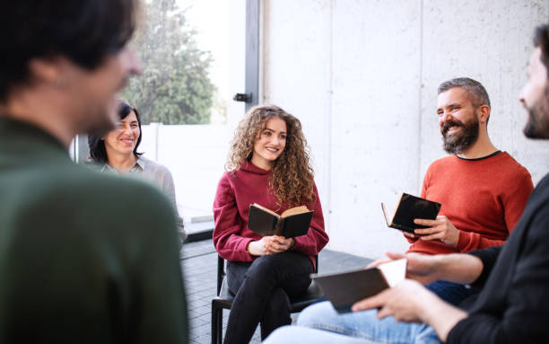 istock Men and women sitting in circle during group therapy, reading and talking. 1337579008