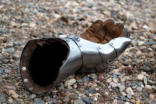 Metallic gauntlet as part of knight equipment abandoned on the ground