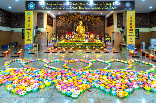 Ho Chi Minh City, Vietnam - March 1st, 2018: Buddhists are preparing to decorate candles on courtyard for sacred Vesak ceremony in Ho Chi Minh City, Vietnam