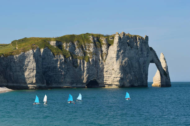 Etretat, France - June 02, 2011: sailboats, beach and rock formation at village Etretat on the coast of English Channel, a preferred travel destination and sea resort in Normandy