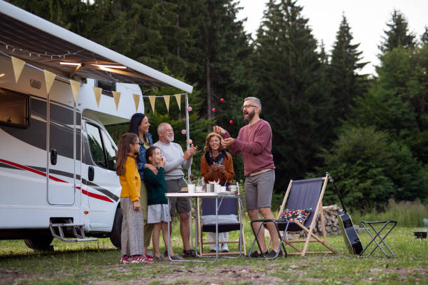 istock Multi-generation family standing and having fun outdoors by car, caravan holiday trip. 1337585923