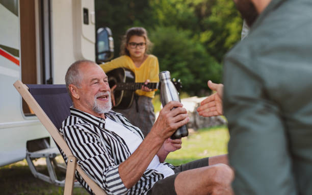 istock Multi-generation family sitting by car, caravan holiday trip. 1337586201