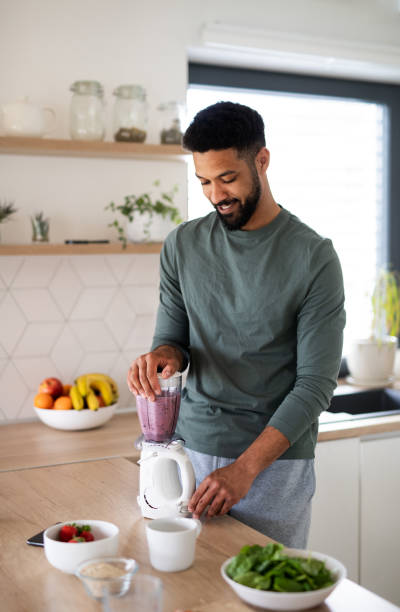 istock Young man preparing healthy breakfast indoors at home, making milk shake. 1337587133