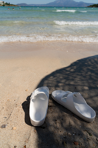 Flip flops on a sandy ocean beach