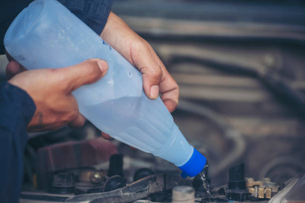 Car Mechanic man hands pouring Deionized purified Distilled water for car battery mechanical service. Close up hands man hold Deionized Distilled liquid water bottle at garage auto mobile car service Car Mechanic man hands pouring Deionized purified Distilled water for car battery mechanical service. Close up hands man hold Deionized Distilled liquid water bottle at garage auto mobile car service liquid battery stock pictures, royalty-free photos & images