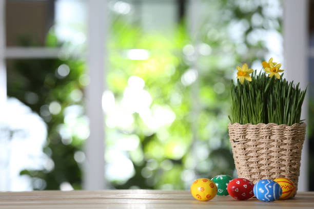istock Colorful Easter eggs and flowers on wooden table against blurred green background. Space for text 1337595671