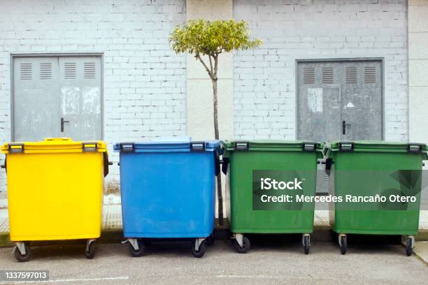 Row Of Multicolored Garbage Bins By The Sidewalk For Recycling Stock Photo - Download Image Now