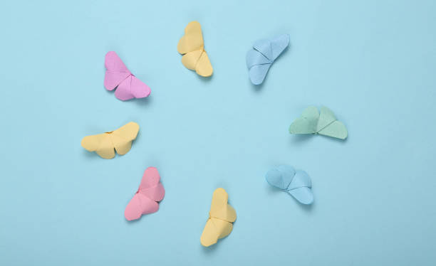 istock Origami butterflies flying in circle on blue background 1337599381