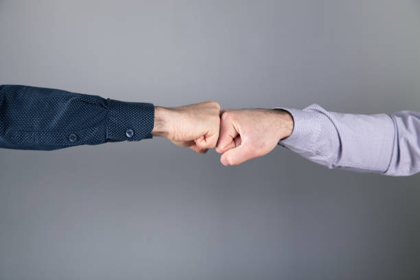 istock men touch with fists on gray background 1337603883