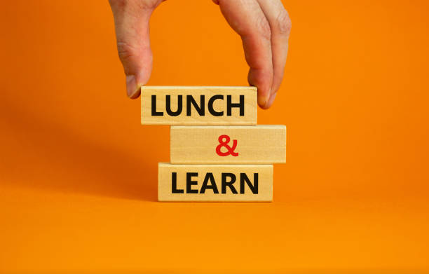 Lunch and learn symbol. Wooden blocks with concept words Lunch and learn. Beautiful orange background. Businessman hand. Copy space. Business, educational and lunch and learn concept. stock photo