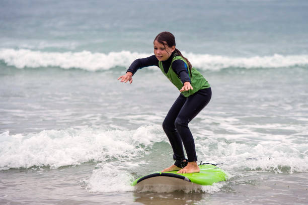 istock cute young girl taking surf lesson 1337605471