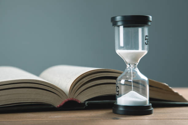 istock hourglass with books on the table 1337605523