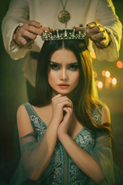 Fantasy medieval couple. Image of lovers - king and queen. hands of man put gothic crown on girl's head. Coronation of woman. vintage costume clothing. Portrait close up girl princess beauty face pareja medieval de fantasía. imagen de los amantes - rey y reina. manos del hombre pusieron corona gótica en la cabeza de la niña. coronación de la mujer. ropa de vestuario vintage. retrato de cerca de la cara de belleza de la princesa chica.