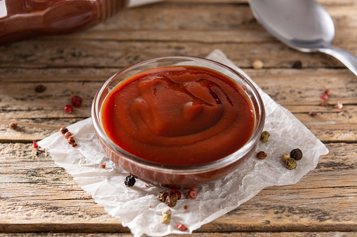 Barbecue sauce in a bowl on rustic wooden table