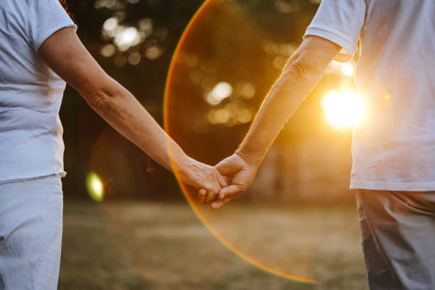 istock Romantic senior couple walking in nature at sunset 1337608668
