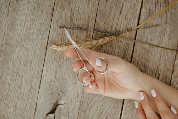 istock Hand with manicure scissors on wooden table 1337612476