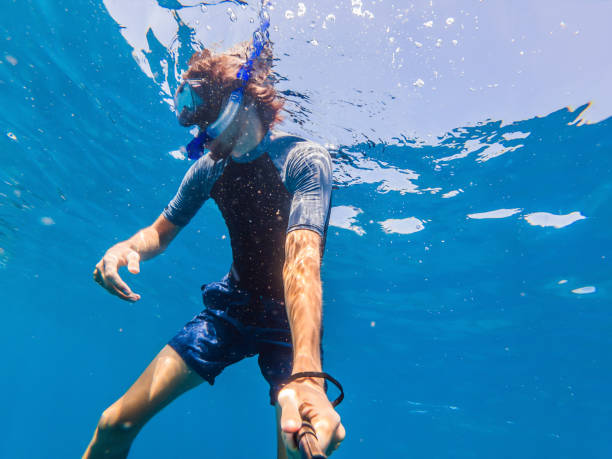 istock Man with mask snorkeling in clear water 1337613383