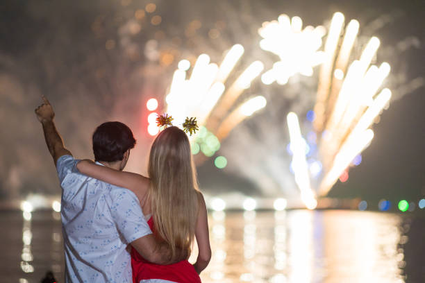 istock Young couple enjoy firework during celebration festival on the beach. 1337614145