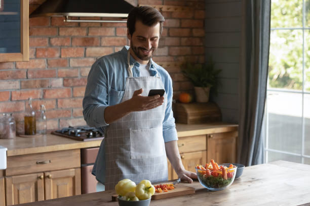 istock Smiling Caucasian man cook with recipe on cellphone 1337616455