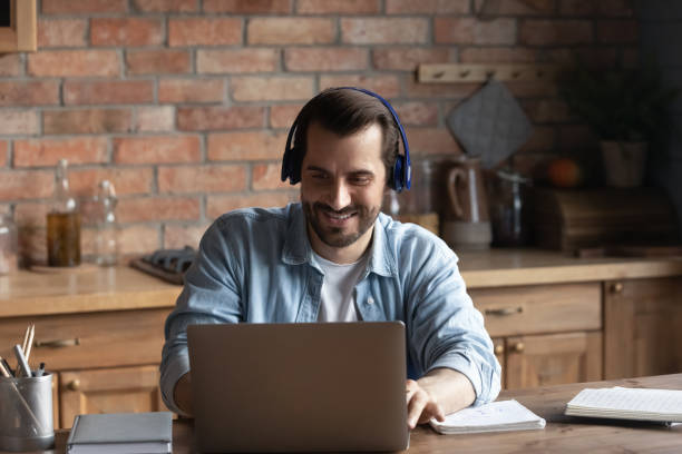 istock Smiling Caucasian man work online on laptop at home 1337616460