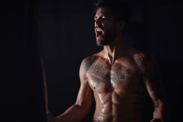 Shot of a handsome young man standing alone in the gym and screaming during his workout I'm ready to go! chest tattoo men stock pictures, royalty-free photos & images