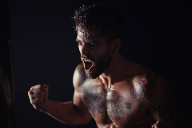 Shot of a handsome young man standing alone in the gym and screaming during his workout Getting that adrenaline boost chest tattoo men stock pictures, royalty-free photos & images