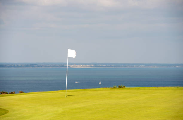 Golf flag on green overlooking Poole Bay, Dorset, England