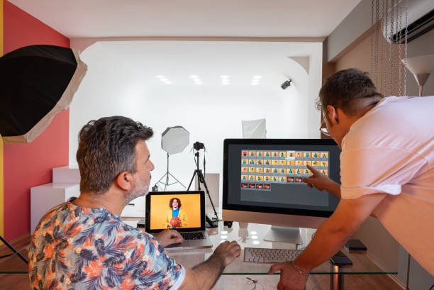 istock Couple of photographers working on computers in the studio 1337623545