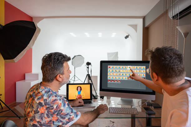 Couple of photographers working on computers in the studio
