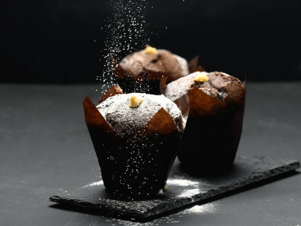 istock baked chocolate muffin on a black table sprinkled with powdered sugar, delicious dessert 1337623959