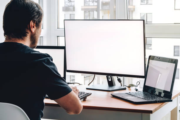 istock Man at workplace with two laptops and monitor 1337627713