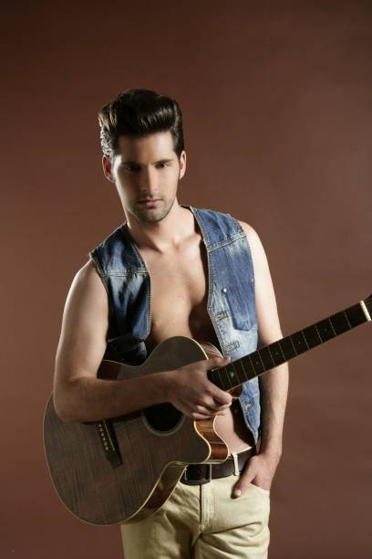 istock sexy young man musician guitar player on brown 1337628703