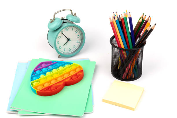 istock School items. Alarm clock, notebooks, pencils for drawing and silicone toy popit on  white background. Concept of education, back to school, creativity and learning. Copy space. 1337632728